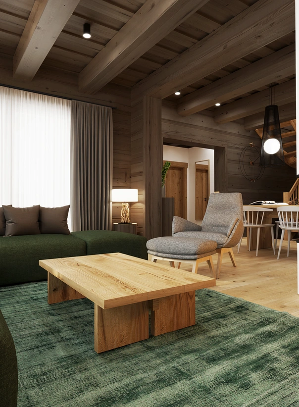 Obývacia izba v drevenici, navrh interiéru so zeleným kobercom, masívnym dreveným stolíkom a pohodlným kreslom.